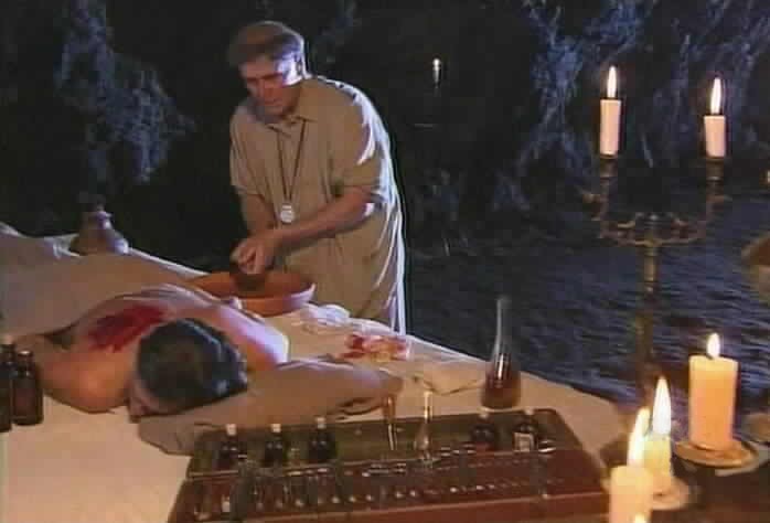 Padre Tomas removes the bullet from Diego's back.