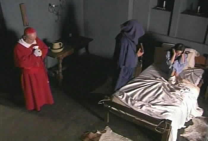 The Cardinal prays as Brother Aaron prepares to begin the exorcism.