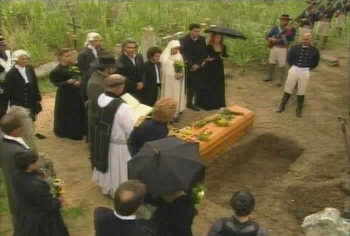 The service continues with the family gathered around the grave.